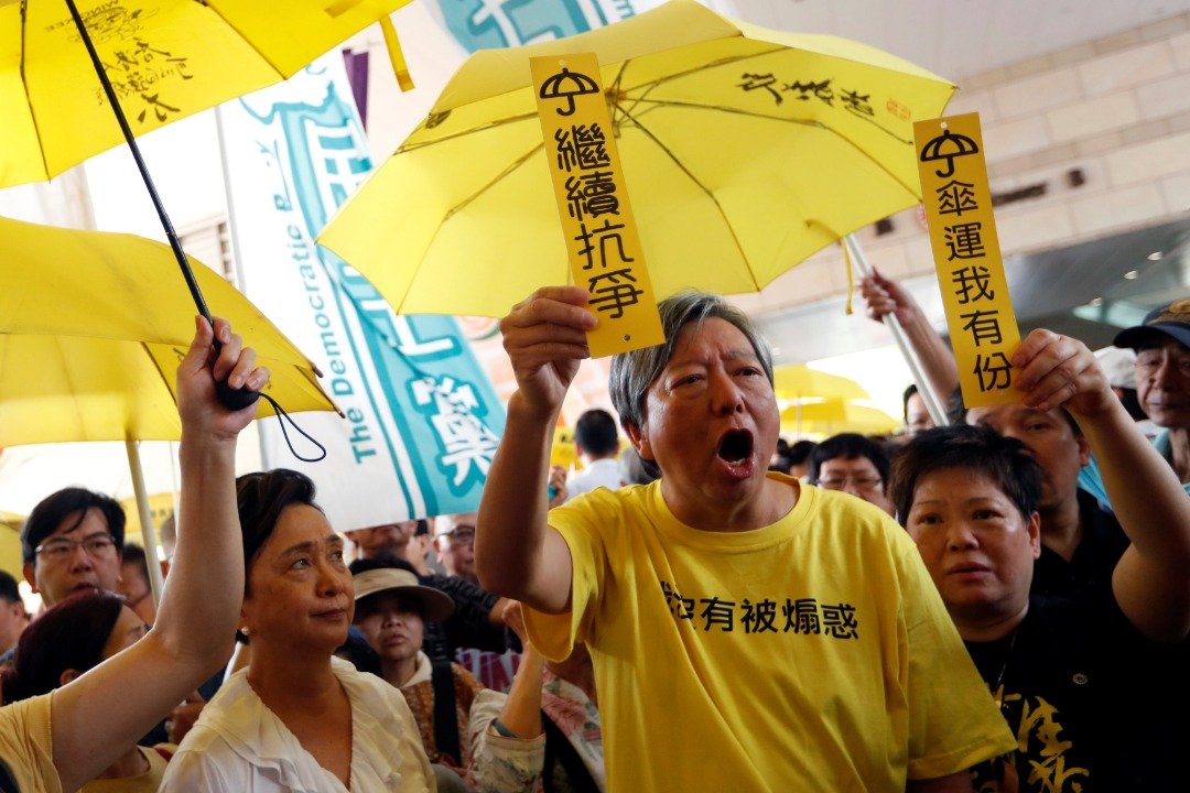 民主派支持者穿上印有“我没有被煽惑”的黄色T恤、撑起黄伞，并举起写上“继续抗争”的牌子，到法院支持被控的占中被告。