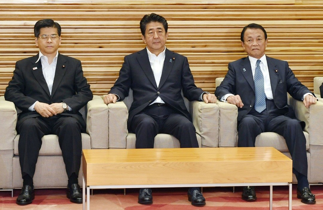 日本首相安倍晋三（中）、兼任财务部长的副首相麻生太郎（右）和国土交通部长石井启一，出席周五的内阁会议。当天的会议决定，把韩国剔除出“白名单国家”。
