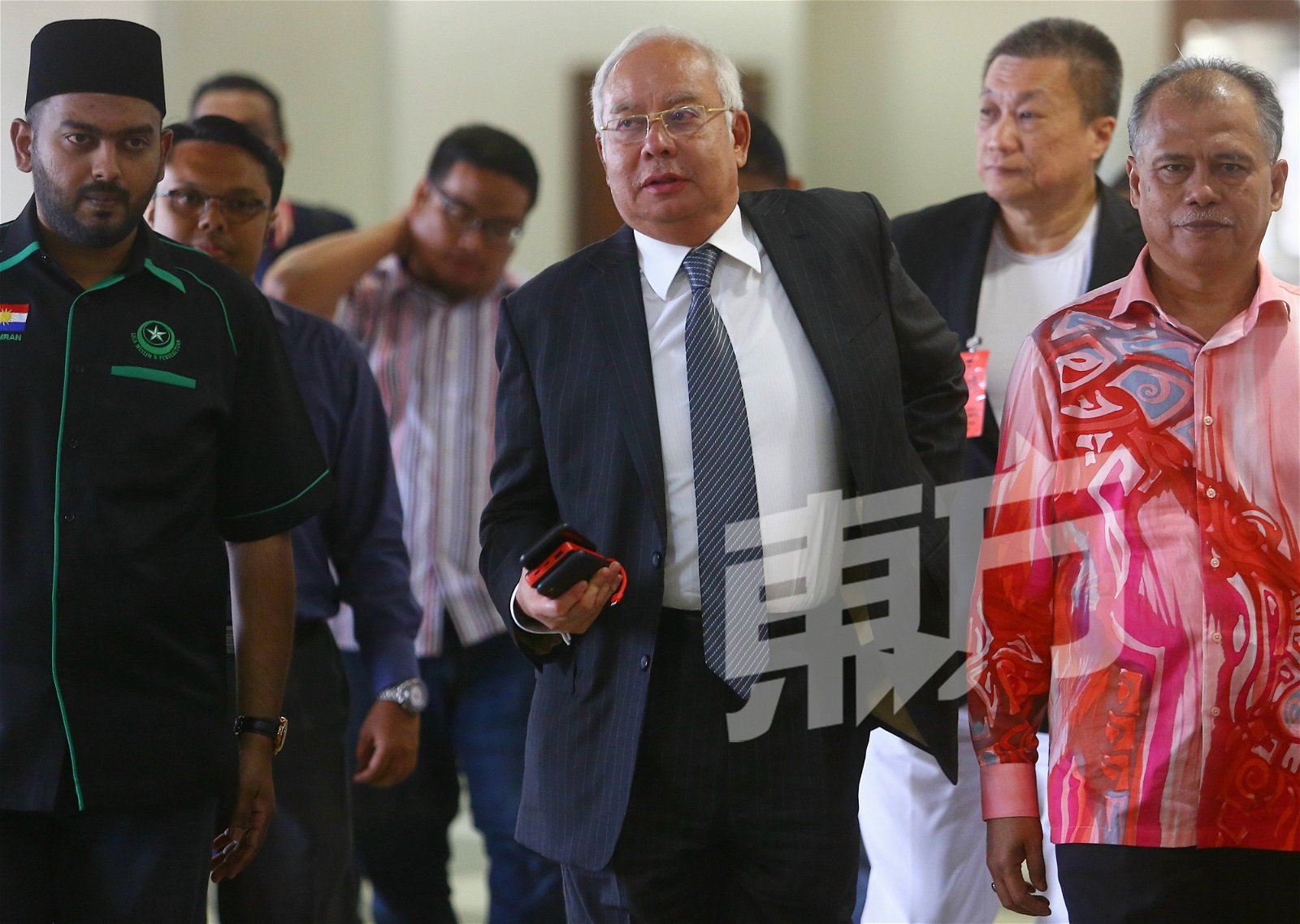 纳吉（中）周一在数名支持者的陪同下，抵达吉隆坡高庭出席SRC案件审讯。（摄影：骆曼）