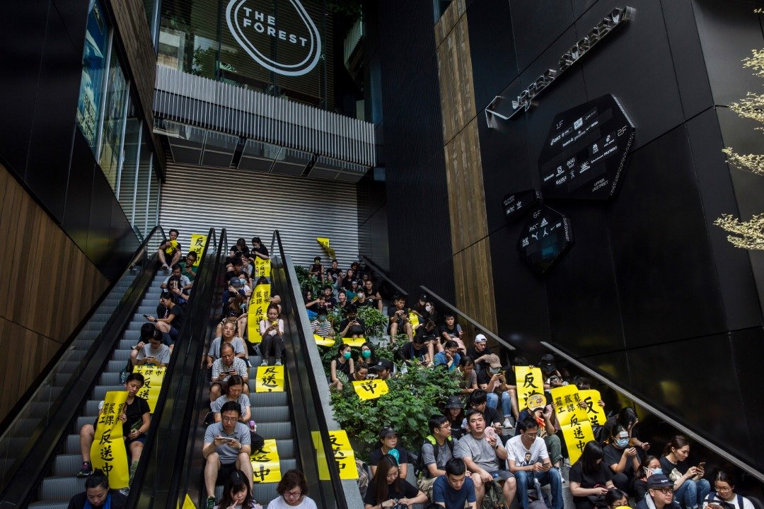 在旺角一购物中心外的阶梯，坐满响应集会号召的示威者，而商铺则已提早关门。
