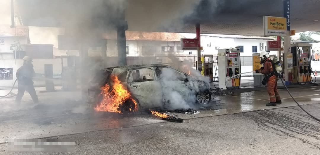 一辆马赛地轿车周六下午在油站内失火燃烧。（消拯局提供）