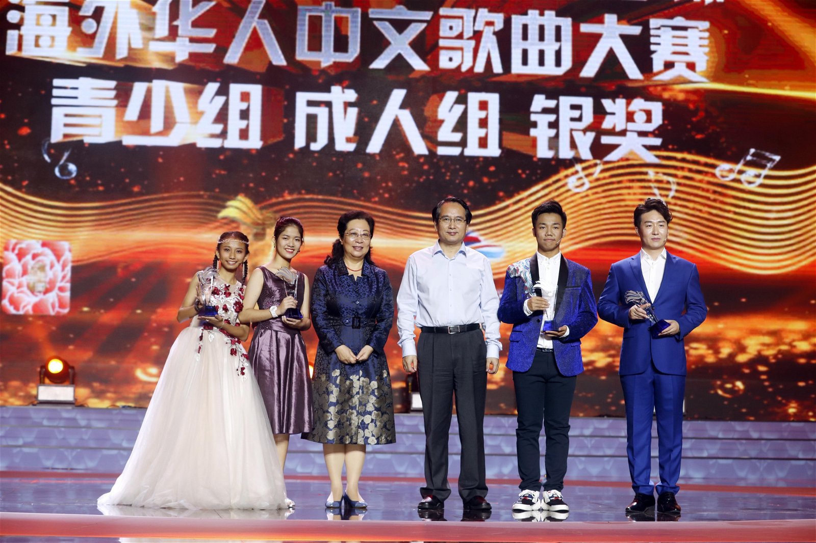 获得青少年组银奖的大马选手许芷妍（左）与另3名青少年组及成人组银奖得主，与颁将人谭天星（右3）及闫傲霜（右4）合影。