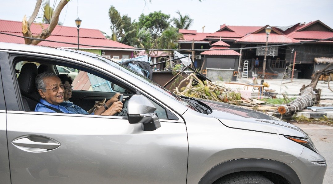 马哈迪（左）亲自驾驶LEXUS休旅车，到受风灾影响的班台丁雅海滩勘察。旁为首相夫人敦西蒂哈斯玛。