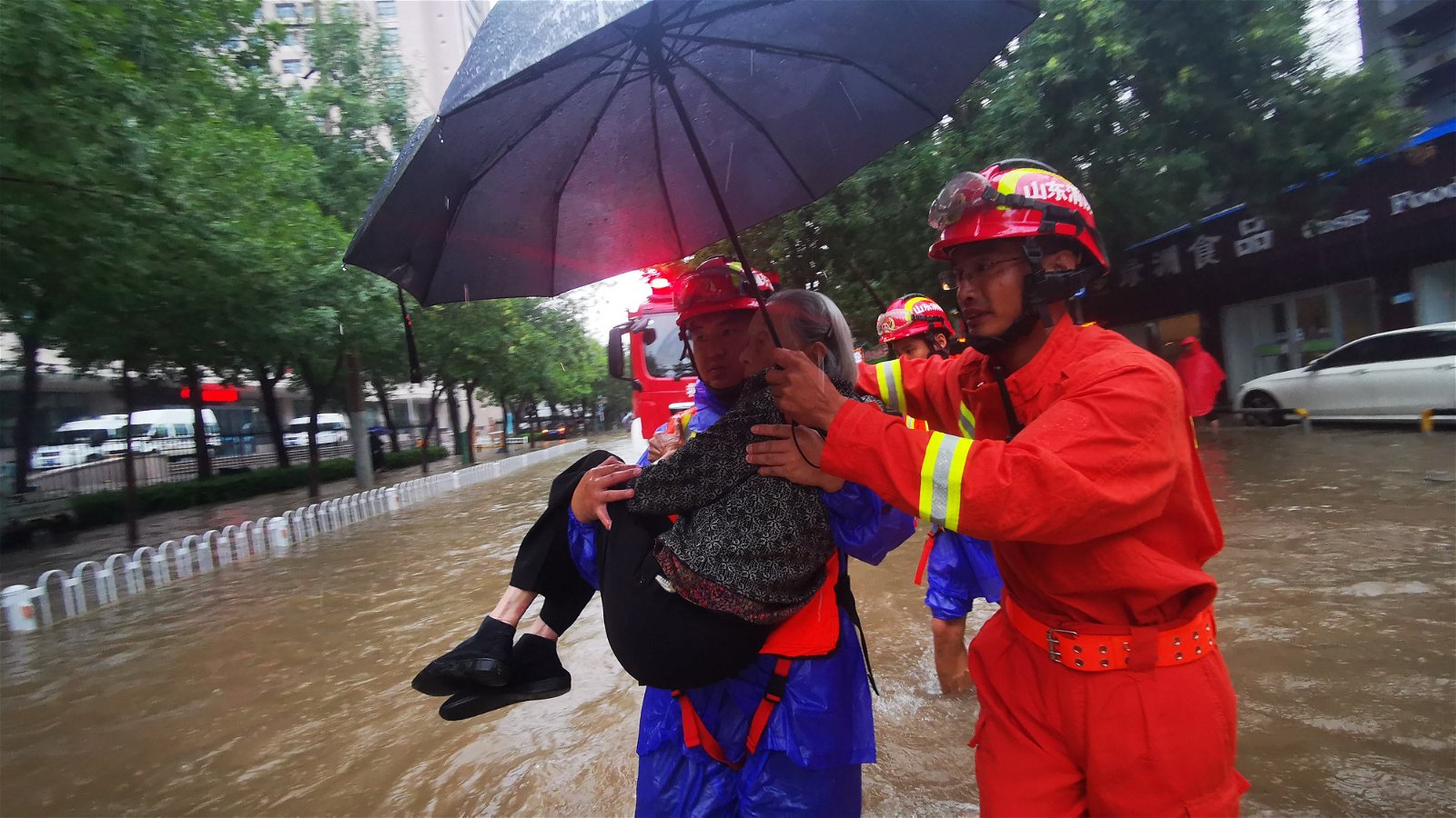 救援人员周日在山东省滨州市滨城区一积水路段救助被困车内的老人。受冷空气及台风利奇马外围云系影响，山东地区已出现暴雨。气象部门提醒，相关部门需做好防暴雨应急工作。
