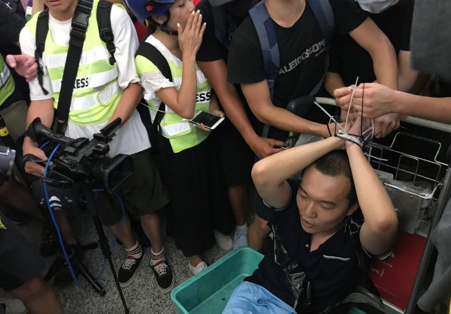 《环球时报》记者付国豪遭示威者绑在行李车上。