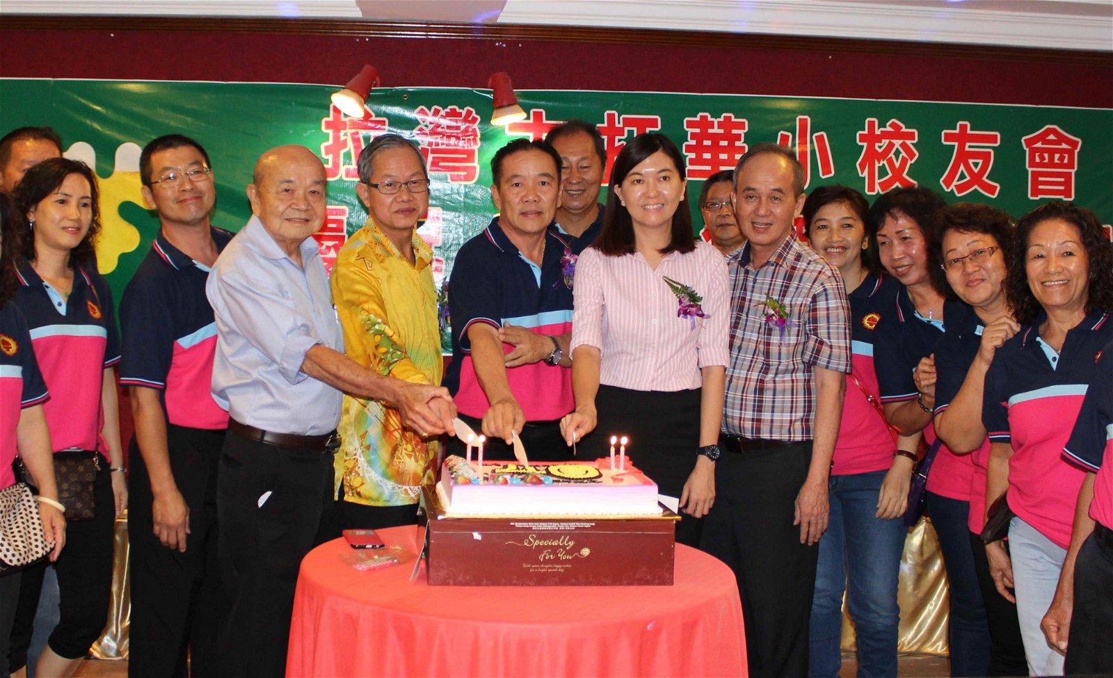 李文材（前左4）出席选区拉湾古打华小校友会周年庆晚宴时，与众嘉宾一起主持切蛋糕仪式，前左5起是林桂清及黄诗情。