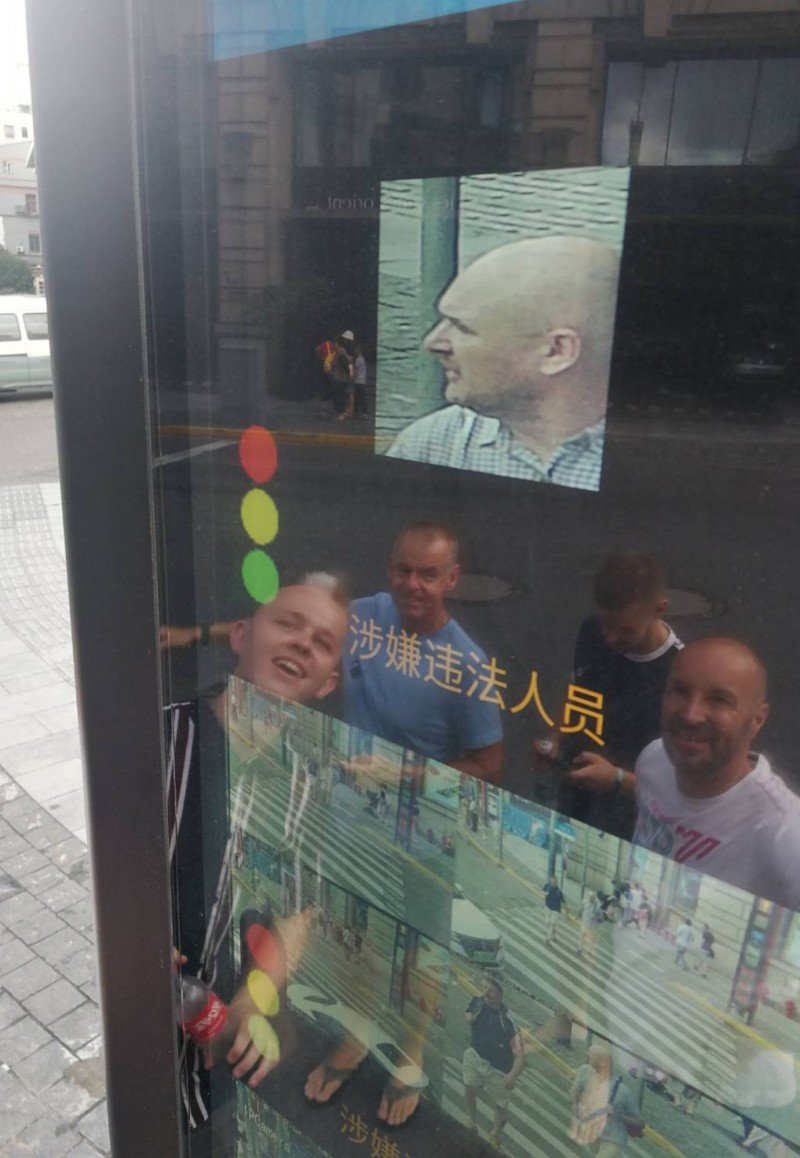 一群外国游客在上海外滩看见同行友人的脸部影像在街头“轮播”，还误以为是什么有趣的事，直到记者向他们说明，才知道友人闯红灯被拍下。