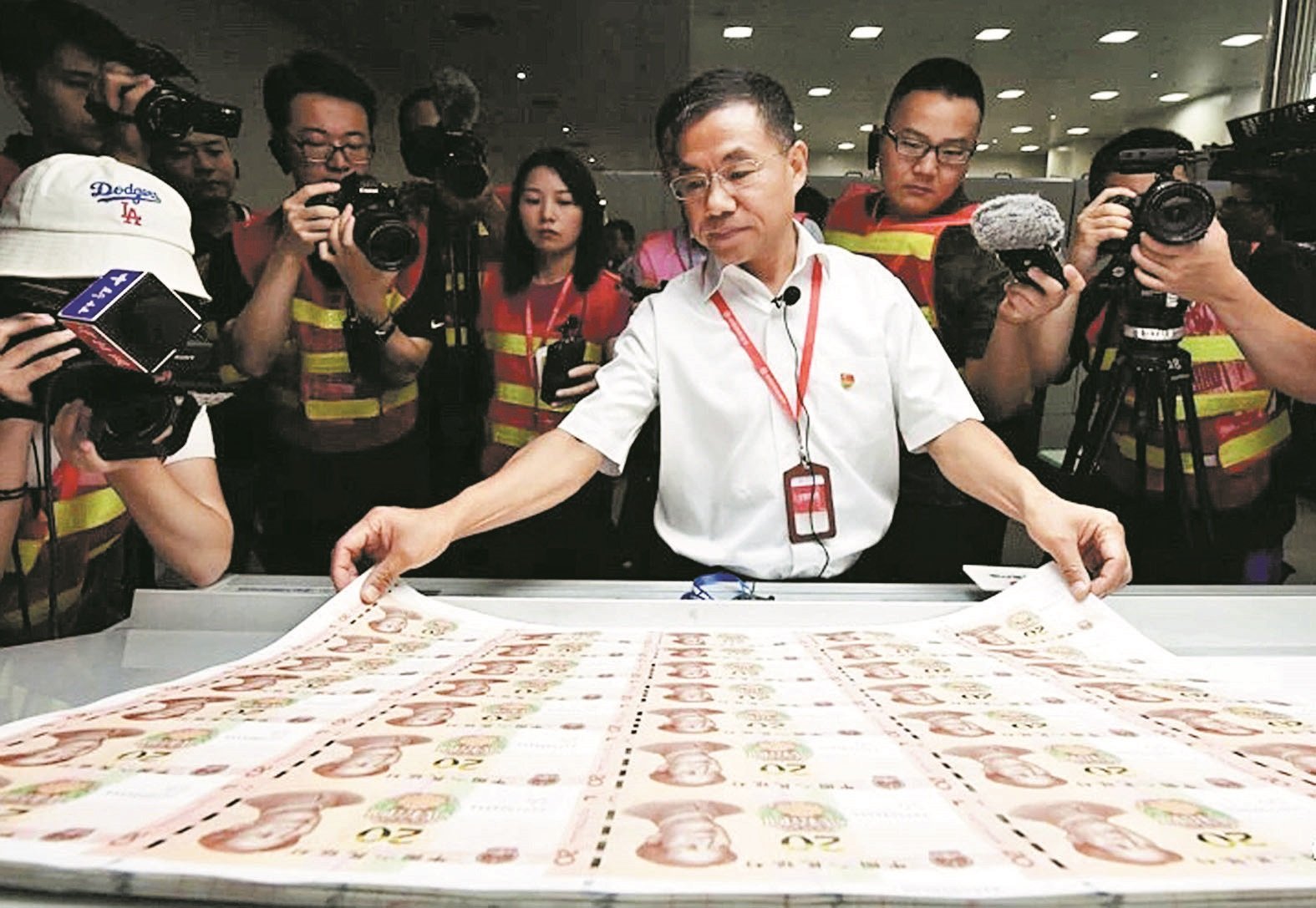 中国印钞造币总公司副总经理郑华，在向记者介绍印钞的丝凸印技术。