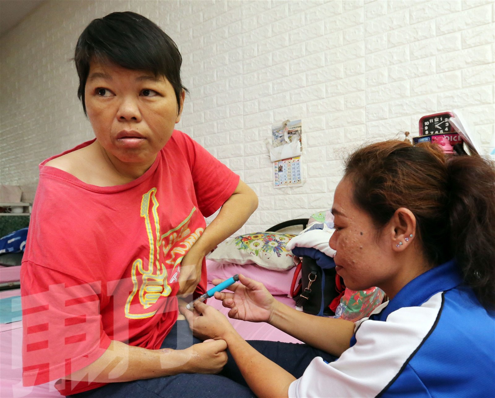 护理员每天早午两次帮王桂香（左）在肚子上打胰岛素，避免血糖过高。（摄影：刘维杰）