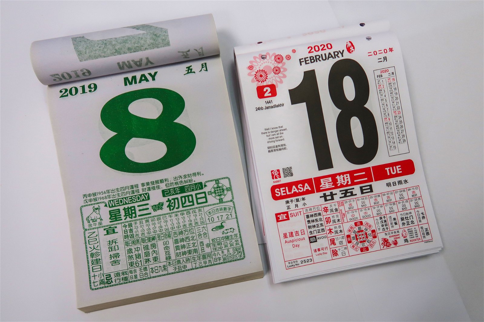 中国制日历（左）与本地制日历摆放在一起，一眼就能看出两者差别。前者仍保持传统形式，纸质较薄，颜色只有绿色（平日）与红色（周末）；后者则采用纸质较厚的日本或韩国纸，颜色为黑红相间，看起来更有质感。