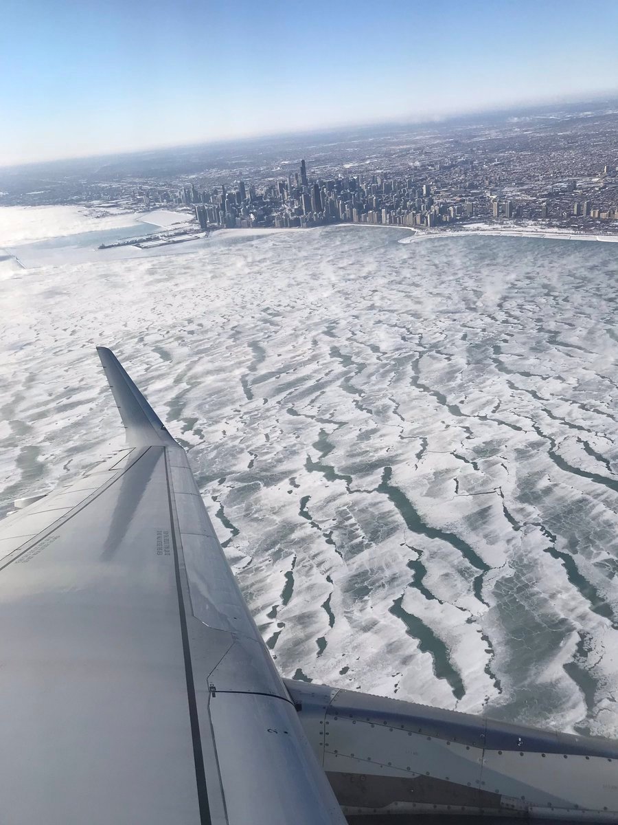 从飞机的窗口向下俯瞰，只见美国芝加哥的密歇根湖湖面均结成冰面。受极地漩涡来袭，芝加哥周三出现了摄氏零下30度的低温，创下该市近25年来最低气温纪录。