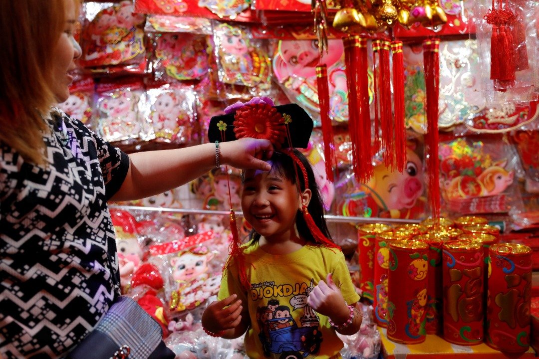 全球最多穆斯林人口的国家——印尼，人口占其总人口数不到5%的华人今年亦喜迎农历新年。这是一名女童在首都雅加达一处传统市集，开心地试戴著一顶用鲜花装饰的旗头。
