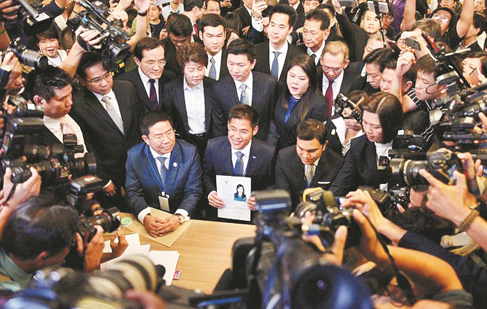 泰爱国党党魁布伊查普（前排中），周五向曼谷选举委员会官员，提交乌汶叻公主的选举登记表格，现场有大批媒体记者包围拍照采访。