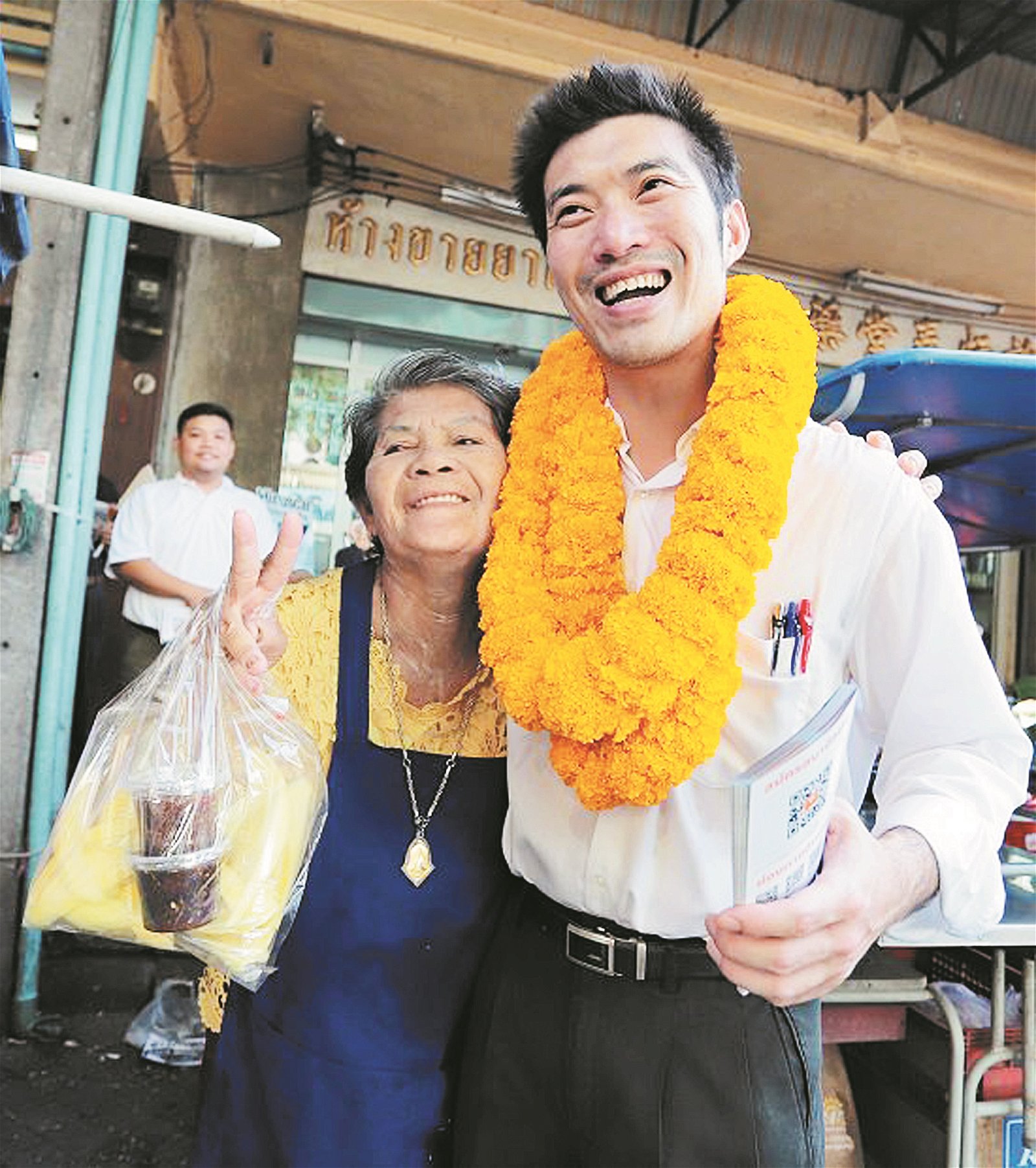泰国未来前进党首相候选人塔纳通（右），到南部甲米府进行拜票活动，并与民众靠肩合照。该党宣扬要在此次选举中，终结泰国军政府的统治。
