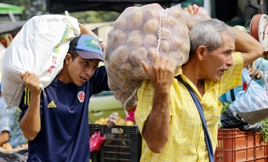 两名委内瑞拉男子在西蒙玻利瓦尔国际大桥附近，扛著一大包的马铃薯在街上行走。由于委内瑞拉的粮食短缺，不少该国的人民均越过边境，前往哥伦比亚购买食物及日常用品