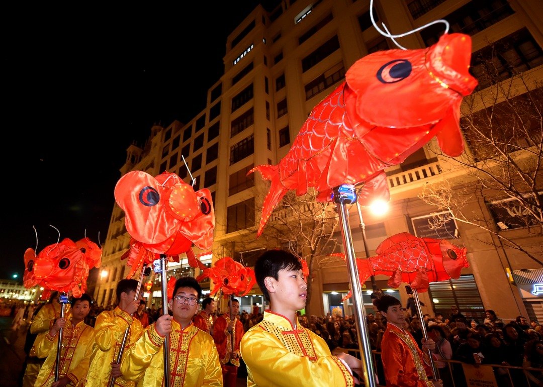 西班牙瓦伦西亚市街头，上周六举办了新年游行活动。一群表演者手拿顶著鲤鱼造型的灯笼，缓缓地走在街上，象征著年年有馀（鱼）的吉祥寓意。