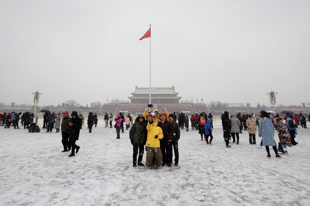 中国北京周二迎来了今年的第二场雪，处处均可见到漫天飞舞的雪花。这是游客们在雪花飘零的天安门广场前自拍留念，虽然气候严寒，仍不减游客们的兴致。