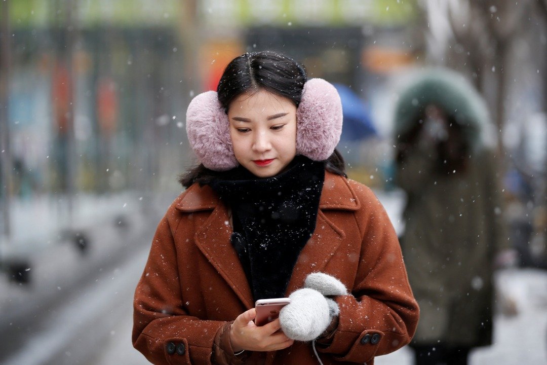 北京气象台周二发布黄色预警信号警告，低气温易出现道路结冰现象，要民众时刻保持警惕。图为一名穿著厚重御寒衣服的女子，走在飘雪的北京街头。