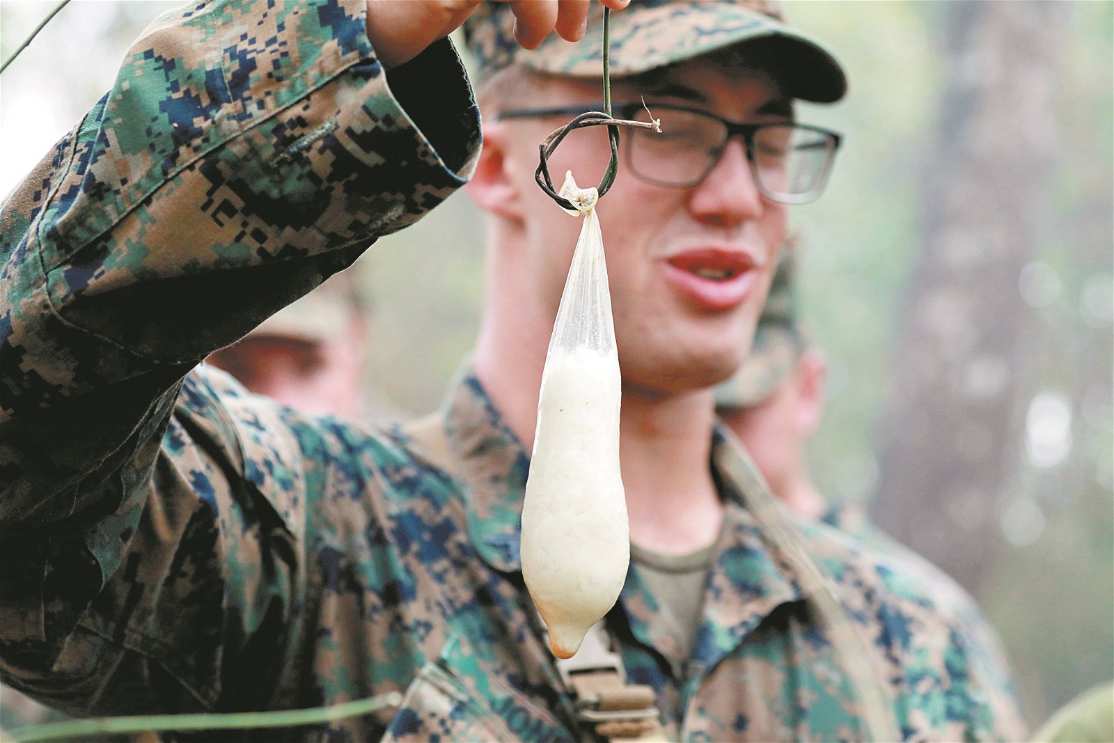 “金色眼镜蛇”联合军演期间，士兵们得利用周遭 所拥有的一切，物尽其用地学习求生。这是一名美 国士兵，举起用安全套烹煮而成的白米饭。 -
