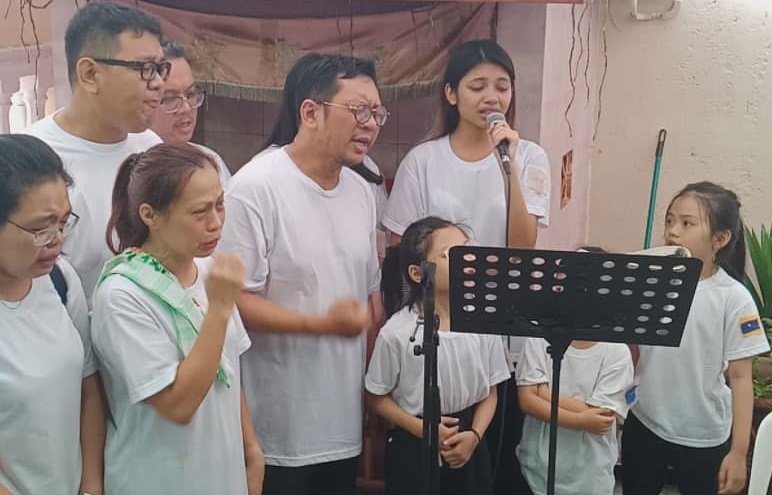 李佩玲（后右）与家人在父亲的丧礼上，哀唱4首歌，用歌声泪别父亲。