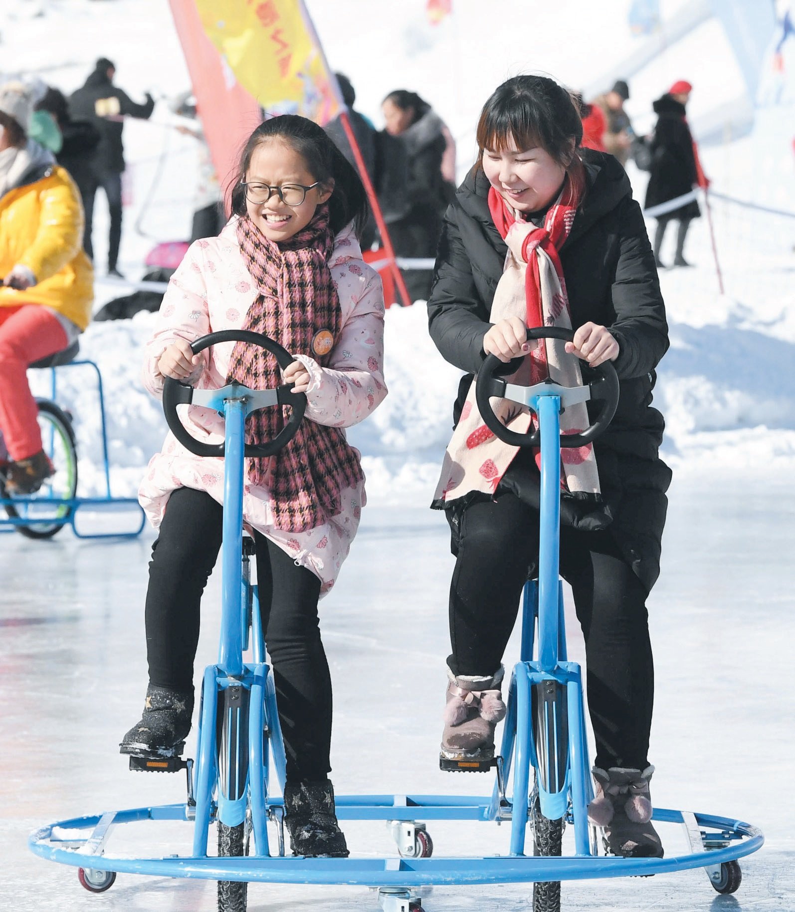 天池景区上周日推出赏天池美景、畅游冰雪大世界、天山纳福等主题活动。这是两名游客在天池景区的冰面上骑著特制脚车。