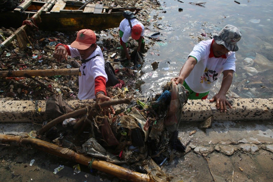 印尼苏门答腊楠榜省首府班达楠榜上周四的清理活动中，在短短的3个小时内就清理了30吨的垃圾。这是参与活动的当地居民，正将堆积在海边的垃圾搬上岸边。
