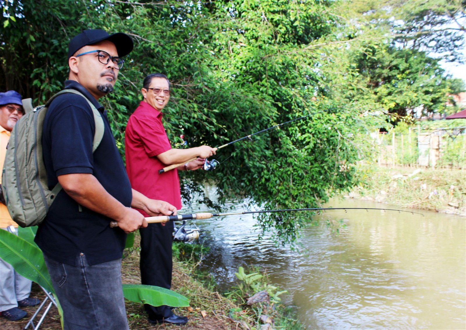 尼萨（左2）出席钓鱼比赛开幕仪式时，与钓鱼爱好在河 畔体验及享受垂钓乐趣。