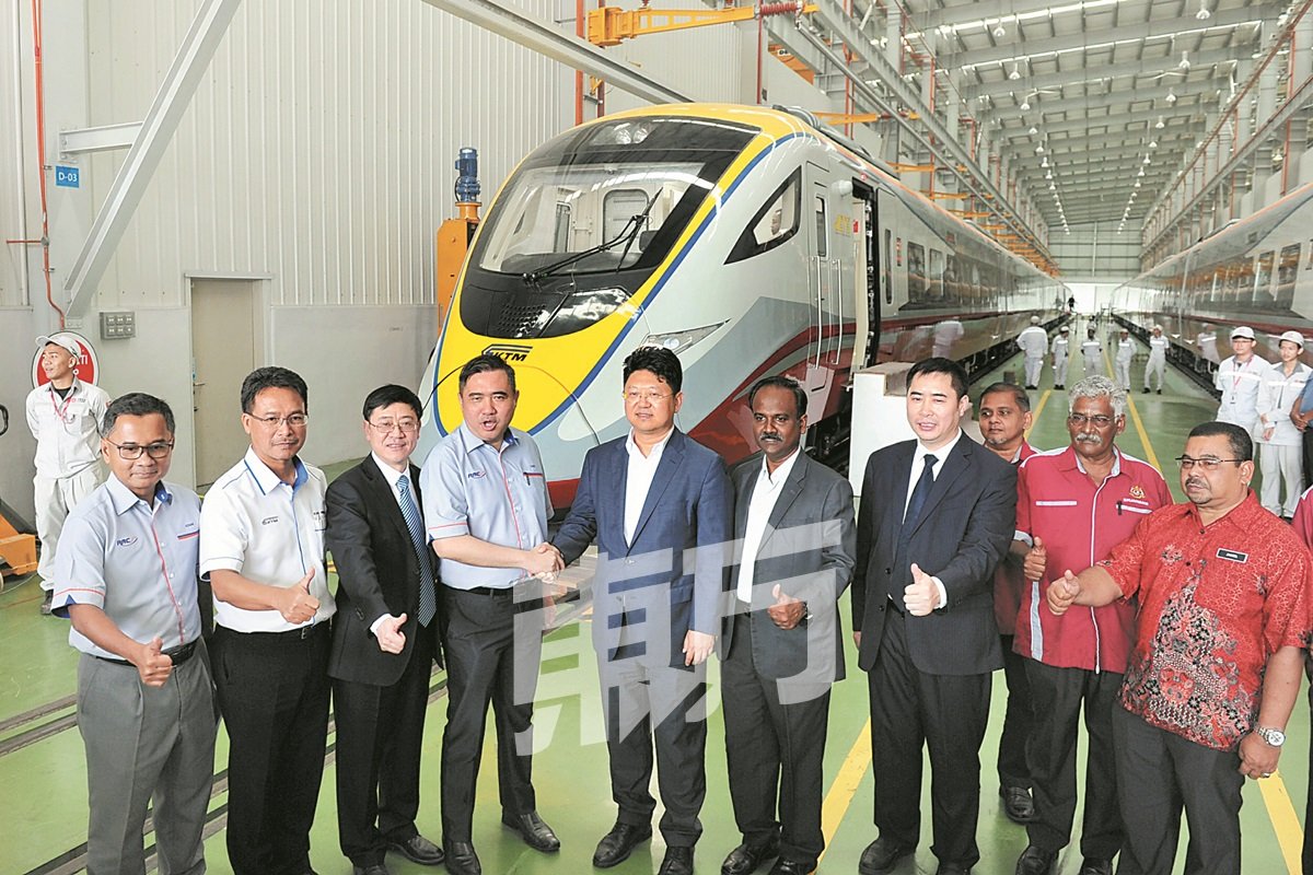 陆兆福（左4）与白天（左五）在参观马来西亚中车轨道交通装备有限公司后握手，见证马中两国的关系强固。（摄影：连国强）