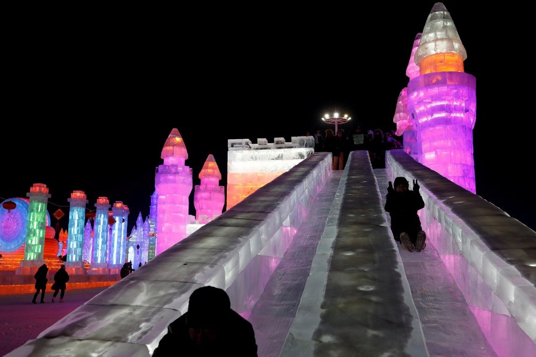 游客们在“冰雪大世界”溜著用冰块雕塑而成的滑梯，玩得不亦乐乎。