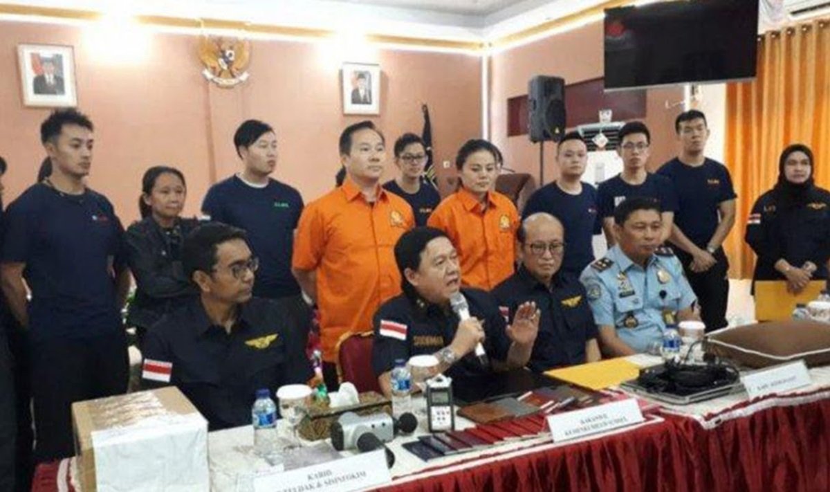印尼巨港移民局等官员于日前召开记者会，指包括梁润江（站者男橙衣者）在内的20名外籍人士，因为违法在印尼进行商业活动而被逮捕。