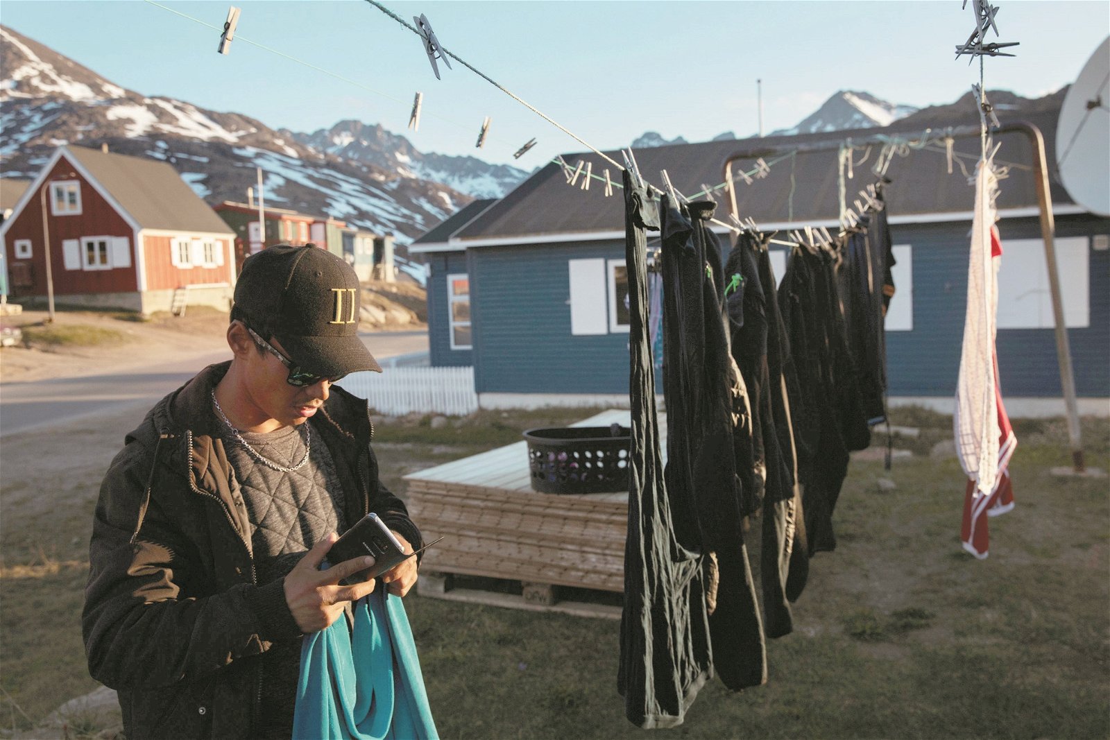 调查发现，约有1/8的格陵兰岛居民直接感受到气候变迁的影响，近一半的人认为气候变迁已经伤害到他们。这是一名塔西拉克镇居民将衣服挂在绳子上晒干。