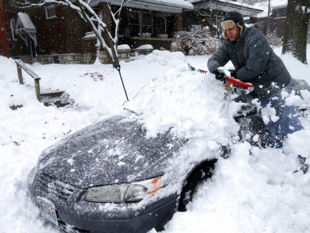 密苏里州圣路易斯市周边地区的积雪超过30公分，当地居民克利福德正吃力地将堆积在车身的积雪铲走。