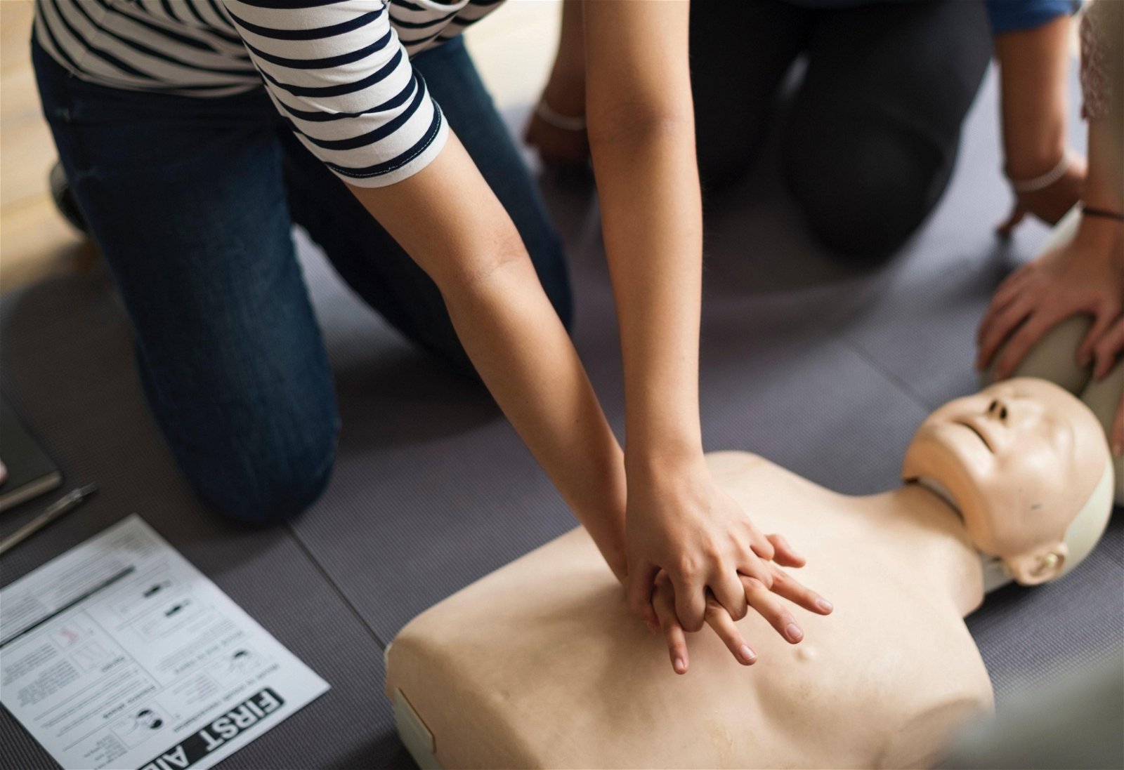 如图所示，进行CPR心肺复苏术时，施救者需双手交叠，放在患者胸口处用力按压，切勿慌乱。