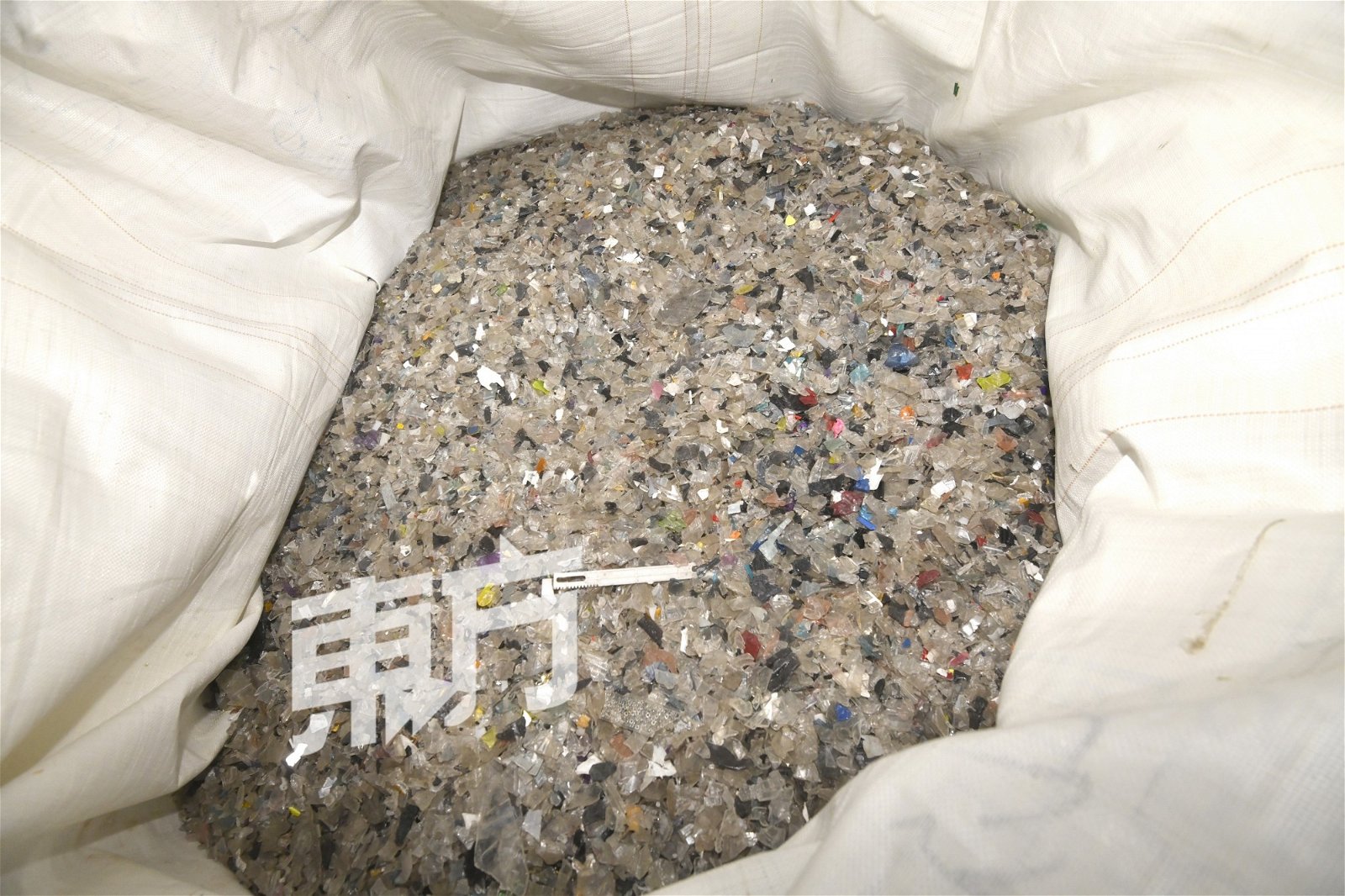 麻包袋皆装满塑料颗粒，环境局官员表示这些颗粒会造成严重的海洋污染。（摄影： 伍信隆）