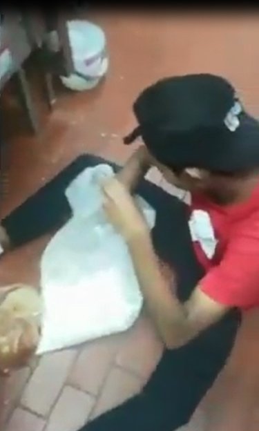 网上流传新加坡肯德基员工被拍到在地上处理食物的视频。（图取自面子书）