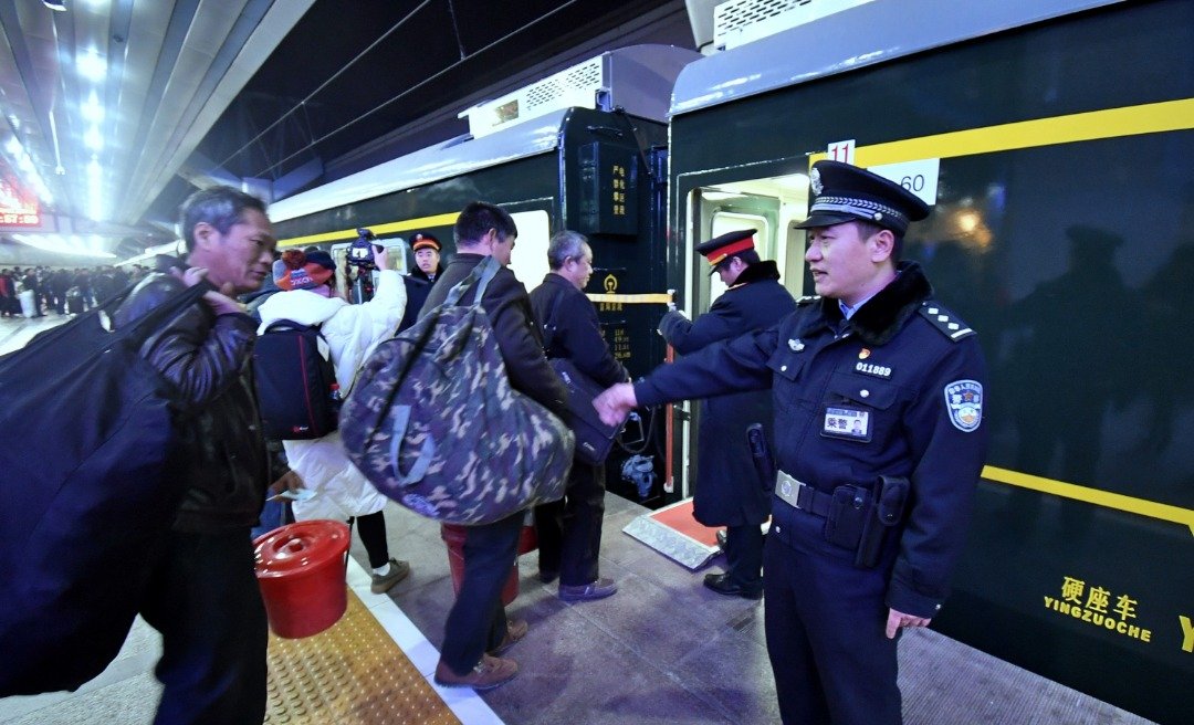 今年春运，中国当局将会严惩一切不文明的行为。这是铁路公安局乘警在北京站的站台上，引导一名背著厚重行李的乘客有秩序地登上回乡的春运列车。