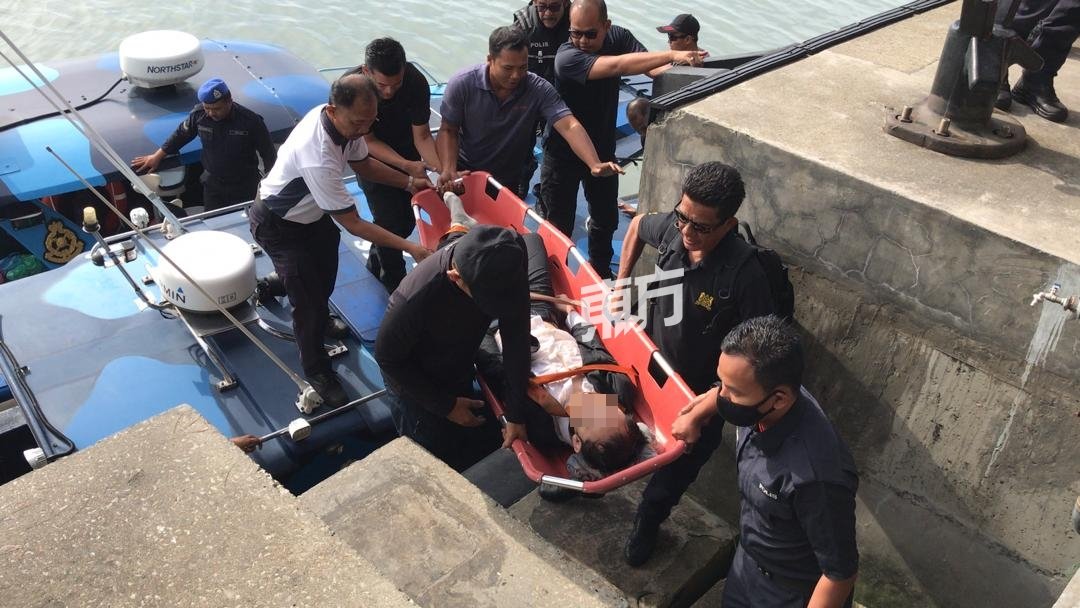 搜救队将尚有气息的自杀者抬上岸，送往医院急救。