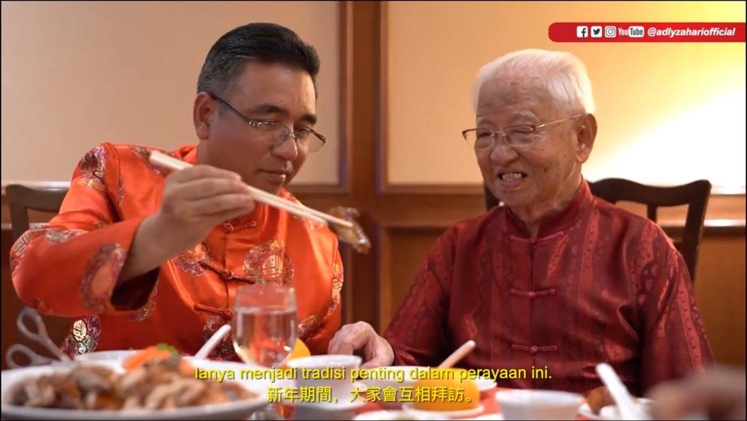 阿德里在中文贺年短片中，夹菜予林瑞源，两人相谈甚欢。