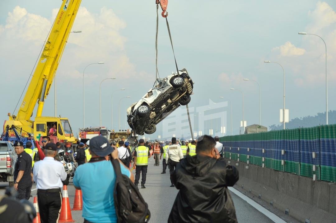 经过约5次的拖吊后，白色休旅车终于被吊车从海里吊上槟城大桥。（摄影：蔡开国）