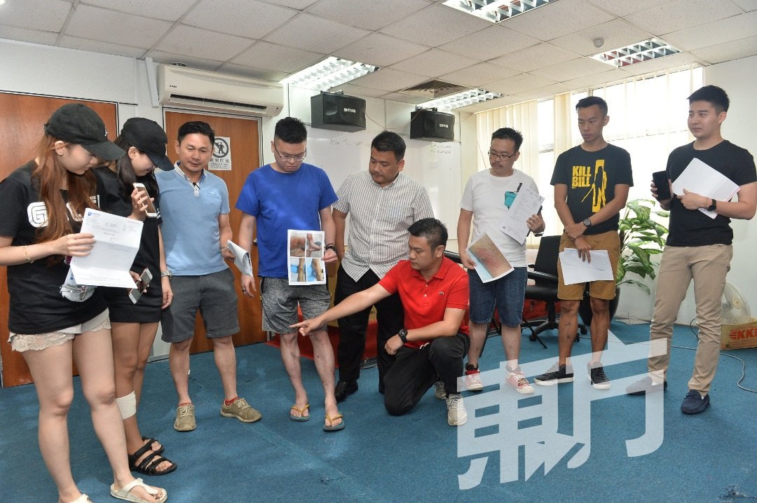 薛富丰(左6)与受害者向记者展示伤口照与医药报告，左5为黄明山。