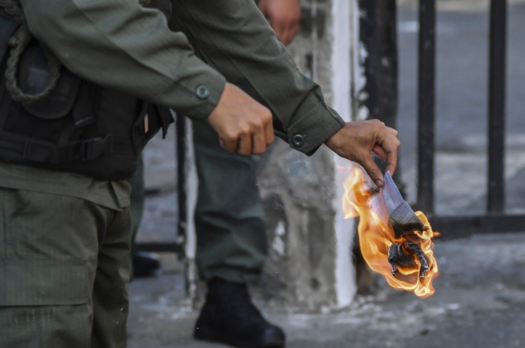 周日在首都加拉加斯军方总部入口处，一名士兵将反对派示威者派发的特赦法副本当场焚毁，以示对马杜罗效忠。