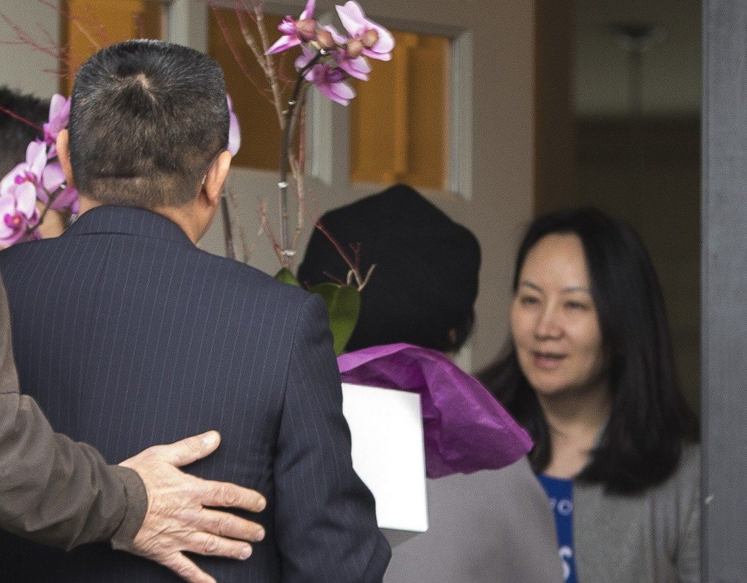 孟晚舟（右）上个月11日获得加拿大法庭批准保释;这是她在获保释后隔天，中国驻温哥华总领事佟晓玲与3名人员，抵达其住家探访。当时孟晚舟亲自开门，微笑接过鲜花。