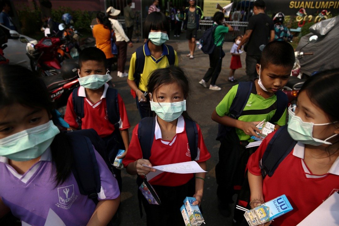 空气污染严重，曼谷的400多所学校周三中午开始停课至周五。学生们都戴上了口罩，等待被接送回家。