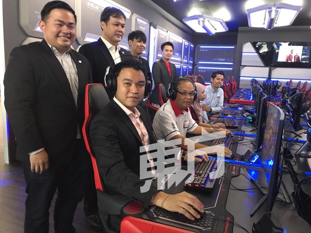 郭子毅（坐者左起）及曼苏体验玩电竞游戏。站者左起为孙清锋及郑福添。