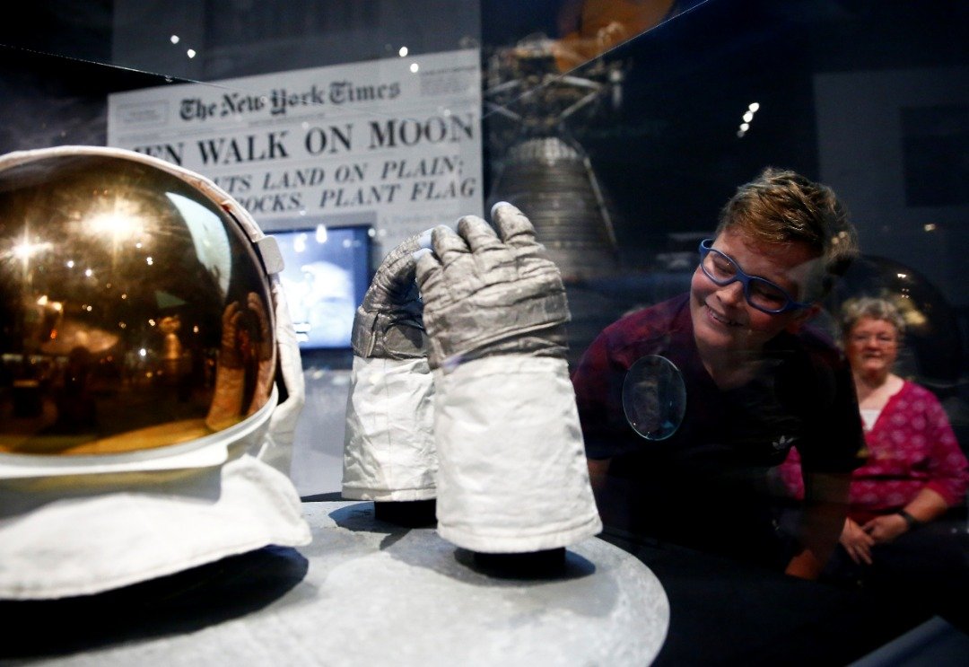 民众在西雅图飞行博物馆的展览中，细看“阿波罗11”号任务太空人奥尔德林，当年登月时穿戴的太空服和手套。