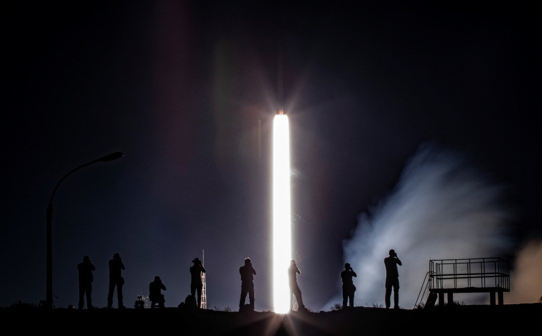 一众摄影师在火箭升空的时候各就各位按下快门，捕捉火箭升空英姿。