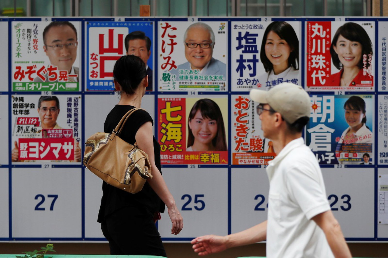 东京市民周日在投票前，仔细阅读墙上竞选海报。日本这次选举共有104名女性候选人参选，创下历年新高。