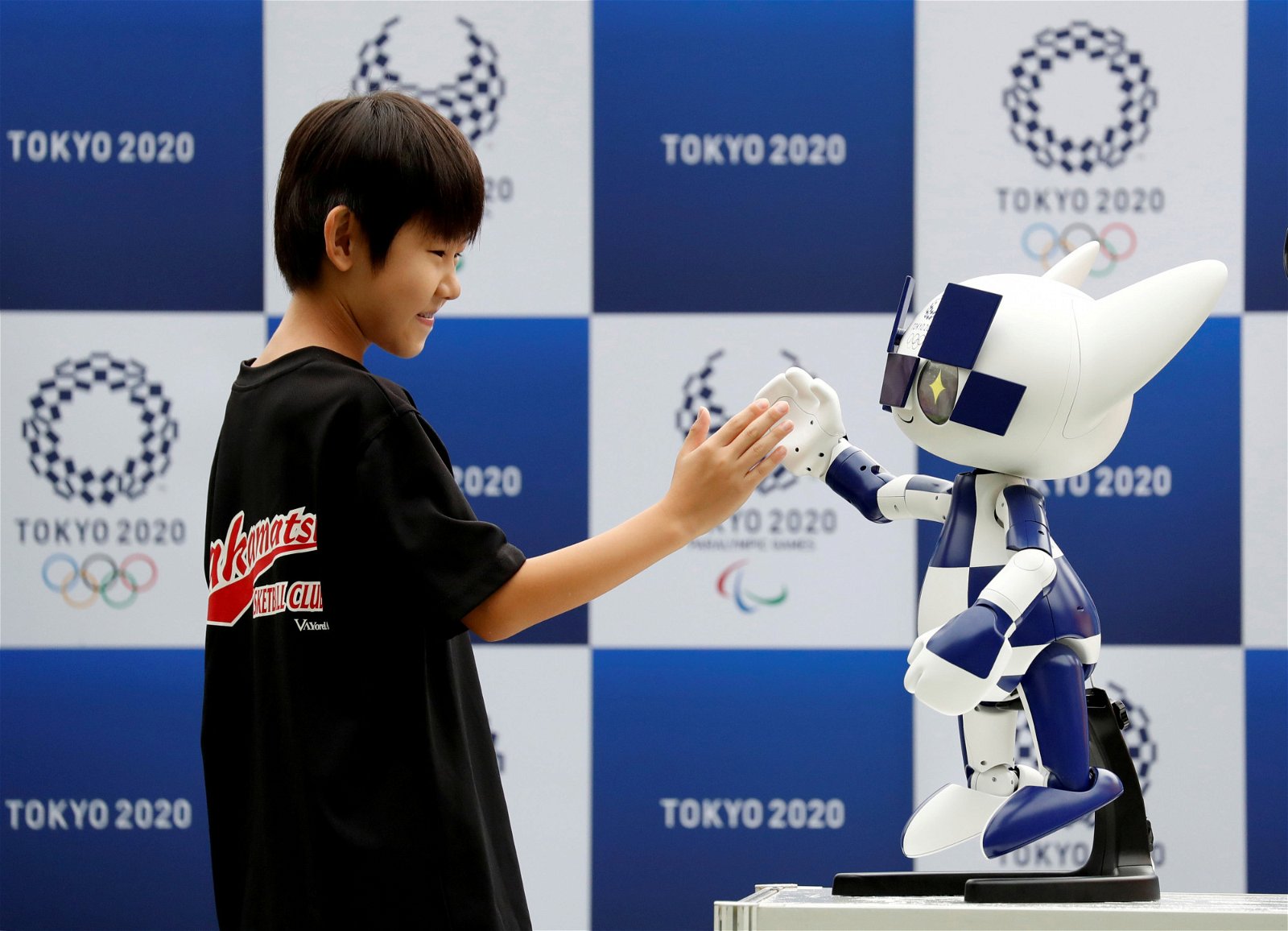一名男孩正与东京奥运会吉祥物机器人——未来永远郎拍手，模样逗趣。东京奥组委早前公布了“东京2020机器人计划”，希望让机器人在奥运会中，为观众提供各种协助。
