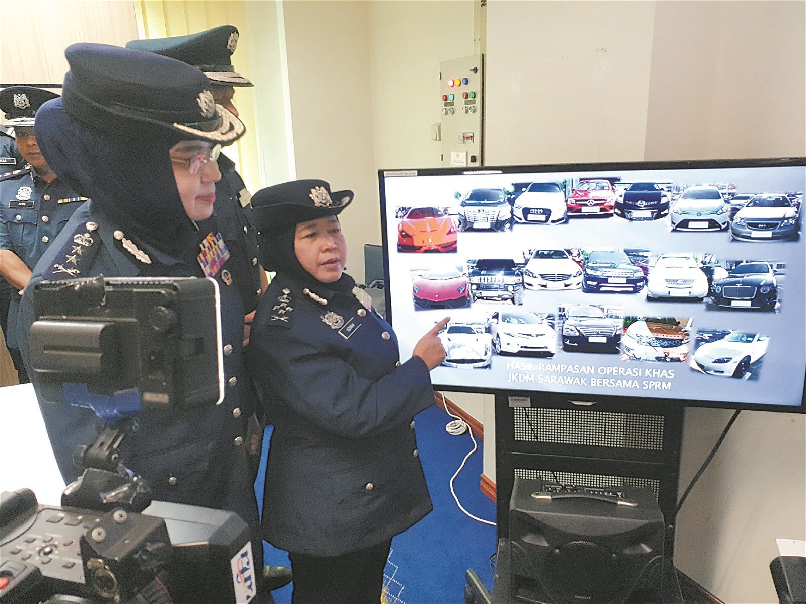 关税局副总监（执法）阿芝玛（左2）展示被扣押的豪华车款。