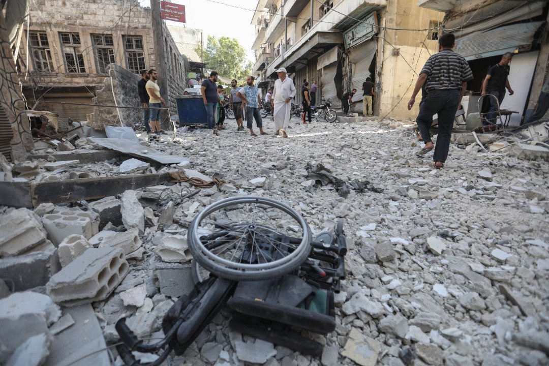 伊德利卜省南部的埃里哈城镇遭到政府军空袭后，留下满目疮痍的废墟及一地的残砖败瓦，当地居民纷纷心有馀悸地聚在危楼外。